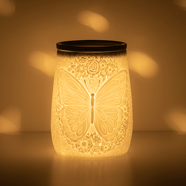 Flight of the Monarch Scentsy Warmer lit up in a dark area showing the beautiful glow
